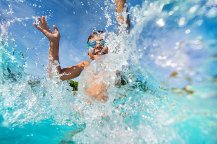 Baderegeln: Kind spritz mit Poolwasser